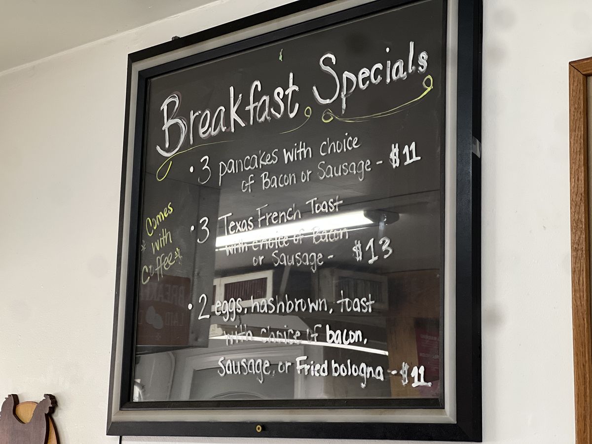Handwritten breakfast specials chalkboard listing pancakes, Texas French toast, and eggs with hashbrown and toast.